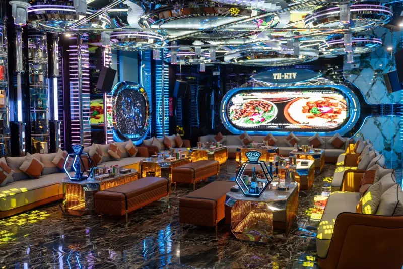 Không gian lớn mang biển TH-KTV, nhiều cụm sofa và bàn đèn vàng